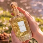 Khadlaj Muse perfume with minimal orange blossoms and whole almonds artistically arranged exclusively on the left and right sides of the bottle.