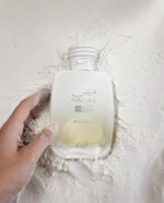 Rasasi Hawas Blanche perfume with minimal blackcurrants and fresh basil artistically arranged exclusively on the left and right sides of the bottle.